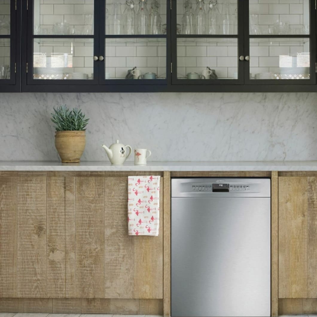 Dishwasher in a kitchen cabinet — example of a wide setting shot showing surrounding plumbing and cabinetry